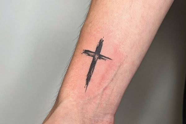 Чёрный крест на предплечье в стиле brush stroke