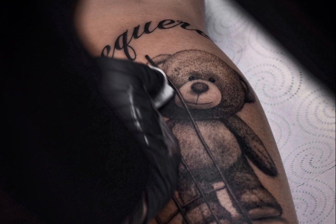 Нанесення тату ведмедика на нозі