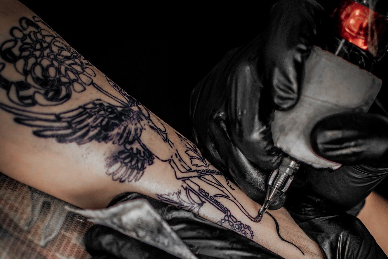 Татуювальник наносить контури на передпліччя