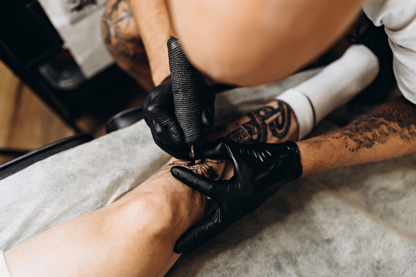 Процесс нанесения тату на ногу