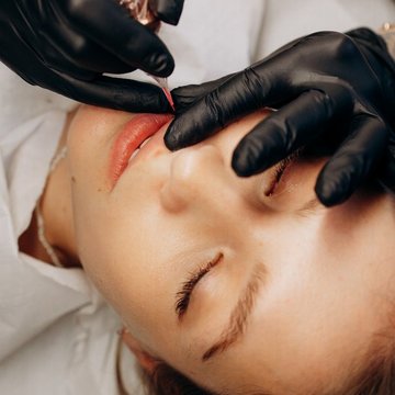 мастер делает перманентный макияж губ