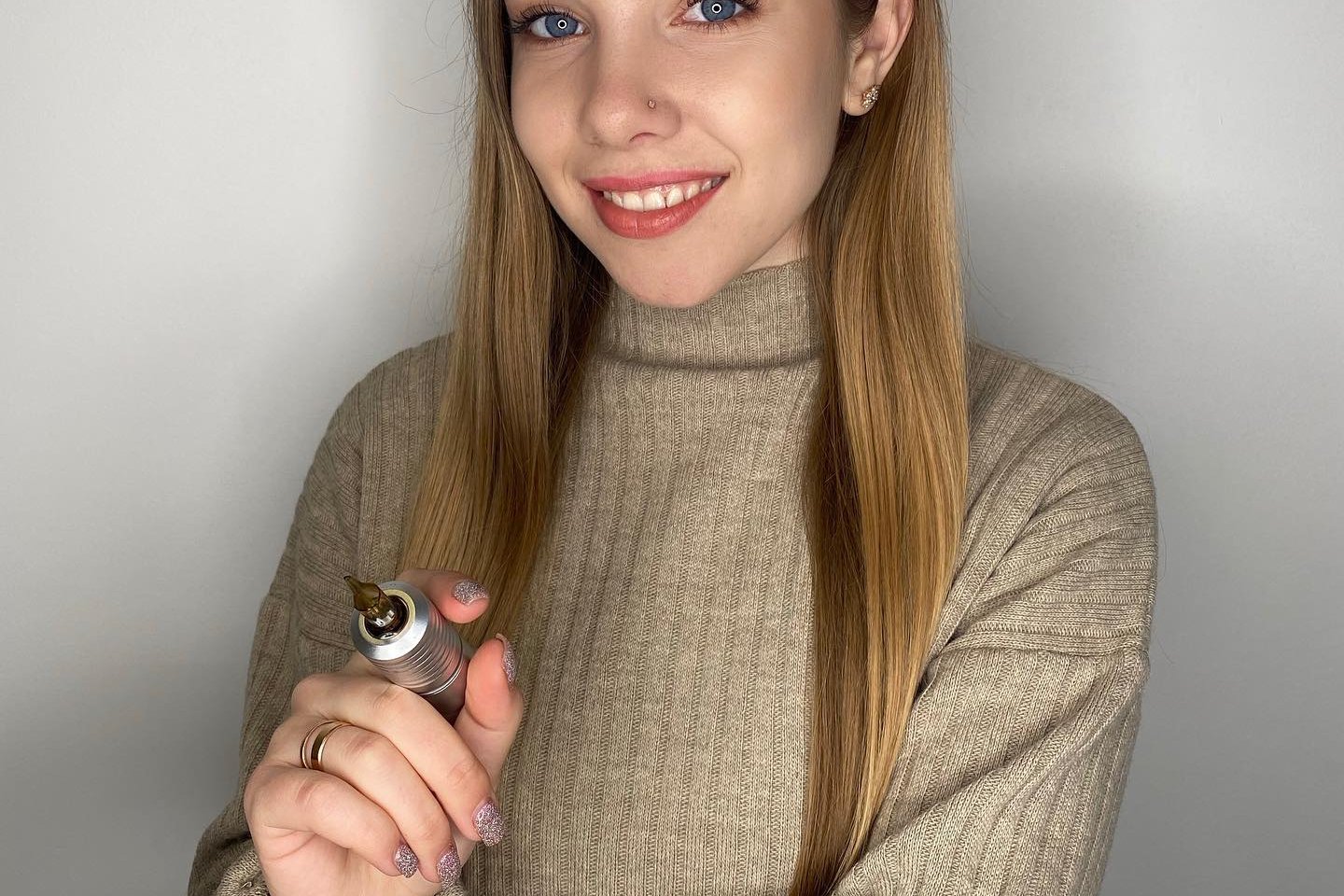 Майстриня тату тримає машинку