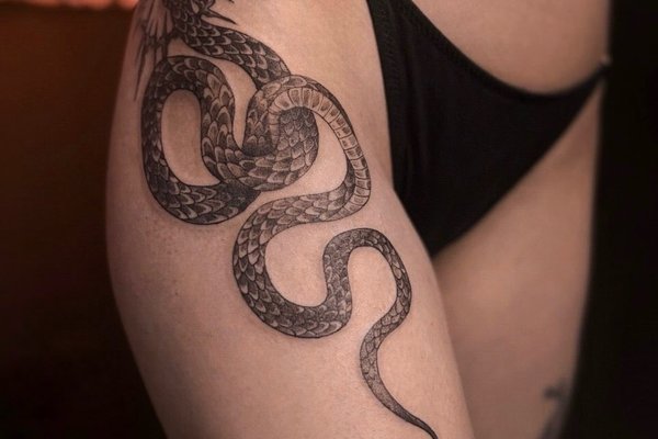 Чорно-біла тату змія на стегні