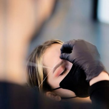 Майстер робить перманентний макіяж брів